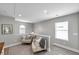 Bright living room with cozy armchairs and plenty of natural light from the large windows at 456 Bayou Village Dr, Tarpon Springs, FL 34689