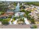 Aerial view showcasing a blue home with water access, palm trees, surrounded by other residences and canals at 4643 Bay Crest Dr, Tampa, FL 33615