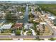 Panoramic aerial view of a waterfront community featuring canal access, lush greenery, and a vibrant blue home at 4643 Bay Crest Dr, Tampa, FL 33615