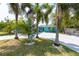 Attractive blue home featuring a well-maintained lawn, decorative palm trees, and a charming directional yard sign at 4643 Bay Crest Dr, Tampa, FL 33615