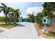 Inviting blue home with a spacious driveway, enhanced by tropical palm trees and unique, decorative yard art at 4643 Bay Crest Dr, Tampa, FL 33615