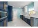 Charming galley kitchen featuring stainless steel appliances, tile floors, and contrasting navy and white cabinetry at 4643 Bay Crest Dr, Tampa, FL 33615