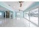 Bright living room featuring tile floors, ceiling fans, and sliding glass doors leading to the backyard pool area at 4643 Bay Crest Dr, Tampa, FL 33615