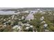 An aerial view of a neighborhood showing homes nestled among trees, with waterfront access at 608 Betmor Ln, Palm Harbor, FL 34683