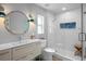 Modern bathroom featuring a sleek vanity, a well-lit mirror, and a glass-enclosed shower with designer tile at 608 Betmor Ln, Palm Harbor, FL 34683