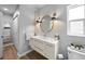Well-lit bathroom with a modern vanity, round mirror, and ample storage space at 608 Betmor Ln, Palm Harbor, FL 34683