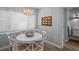 Dining area with a chandelier, blinds, a white table, and chairs that add an elegant touch to the space at 608 Betmor Ln, Palm Harbor, FL 34683