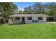 Charming single-story home with a well-manicured lawn and inviting front porch seating at 608 Betmor Ln, Palm Harbor, FL 34683