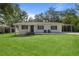 Charming single-story home with a well-manicured lawn and inviting front porch seating at 608 Betmor Ln, Palm Harbor, FL 34683