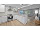 Modern kitchen with stainless steel appliances, sleek white cabinetry, and a gray countertop island with seating at 608 Betmor Ln, Palm Harbor, FL 34683