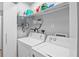 Functional laundry area equipped with a washer, dryer, and storage shelves at 608 Betmor Ln, Palm Harbor, FL 34683