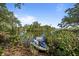 A waterfront view showcasing lush foliage with a jet ski near the water's edge at 608 Betmor Ln, Palm Harbor, FL 34683