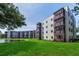 Exterior of a multi-story condo building featuring screened balconies overlooking a pond and landscaped grounds at 6190 80Th N St # 411, St Petersburg, FL 33709