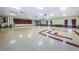 Spacious community center hall with stage, neutral walls and floor, and string lights at 6190 80Th N St # 411, St Petersburg, FL 33709