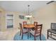 Cozy dining area with round table, four chairs, decorative rug, and view to laundry room at 6190 80Th N St # 411, St Petersburg, FL 33709