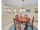 Warm dining area with wooden table, chandelier, and open view to kitchen, creating an inviting atmosphere at 6190 80Th N St # 411, St Petersburg, FL 33709