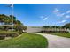 Entrance to Magnolia Sun Center community with manicured lawn, lush landscaping, and mature trees at 6190 80Th N St # 411, St Petersburg, FL 33709