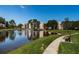 A serene pond with a fountain, surrounded by lush greenery and a walking path with a bench at 6190 80Th N St # 411, St Petersburg, FL 33709