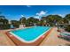 A serene swimming pool area with clear blue water, lounge chairs, and well-maintained landscaping at 6190 80Th N St # 411, St Petersburg, FL 33709