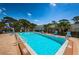 Relaxing swimming pool area with lounge chairs and clear blue water, surrounded by lush green landscaping at 6190 80Th N St # 411, St Petersburg, FL 33709