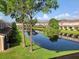 This backyard features a pond with beautiful, lush green grass and trees at 6231 Bayside Key Dr, Tampa, FL 33615
