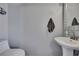 Stylish half bath featuring a pedestal sink, modern faucet, and updated toilet at 6231 Bayside Key Dr, Tampa, FL 33615