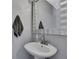 Stylish half bath featuring a pedestal sink, modern faucet, and decorative mirror at 6231 Bayside Key Dr, Tampa, FL 33615