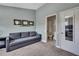 This carpeted bedroom has a gray sofa and a doorway that leads to the bathroom at 6231 Bayside Key Dr, Tampa, FL 33615