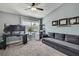This is a bedroom with a gray couch, a plant, a ceiling fan, and a large window overlooking the neighborhood at 6231 Bayside Key Dr, Tampa, FL 33615