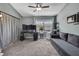 This is a bedroom with a gray couch, a plant, a ceiling fan, and a large window overlooking the neighborhood at 6231 Bayside Key Dr, Tampa, FL 33615