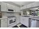 Bright kitchen features white appliances, stainless steel dishwasher, and convenient layout at 6231 Bayside Key Dr, Tampa, FL 33615