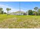 Lush backyard featuring a large lawn and a house with a screened porch at 7206 River Country Dr, Weeki Wachee, FL 34607