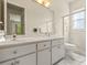 Bright primary bathroom featuring a double vanity, large mirror, walk-in shower, and neutral tile flooring at 7206 River Country Dr, Weeki Wachee, FL 34607