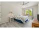 Bright bedroom with neutral tones, a ceiling fan, large windows offering natural light, and wood-look flooring at 7206 River Country Dr, Weeki Wachee, FL 34607
