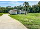 Single-story home featuring a long driveway and well-manicured front lawn at 7206 River Country Dr, Weeki Wachee, FL 34607