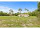Well-manicured front yard featuring a sprawling lawn and palm trees at 7206 River Country Dr, Weeki Wachee, FL 34607