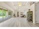 Expansive living room with tray ceilings, sliding glass doors, and wood plank floors at 7206 River Country Dr, Weeki Wachee, FL 34607