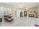 Large living room with tray ceilings, plantation shutters, and wood flooring at 7206 River Country Dr, Weeki Wachee, FL 34607