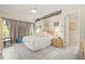 Calm main bedroom with king bed, gray carpet and curtains, with decorated shelf overhead and natural lighting at 7206 River Country Dr, Weeki Wachee, FL 34607