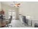 A bright office space featuring two desks, comfortable seating, and glass doors leading to the outdoor area at 7206 River Country Dr, Weeki Wachee, FL 34607