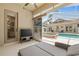 Entertaining patio with lounge chairs, TV, glass panelling and access to hot tub and pool at 7206 River Country Dr, Weeki Wachee, FL 34607