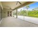Spacious screened patio with ceiling fans and sliding door to the home interior, overlooking lush landscaping at 7206 River Country Dr, Weeki Wachee, FL 34607