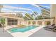 Luxurious screened-in pool area with a spa and elegant columns for stylish outdoor living at 7206 River Country Dr, Weeki Wachee, FL 34607