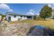 A spacious backyard features a screened-in patio, complemented by mature trees and a clear blue sky at 7777 117Th St, Seminole, FL 33772