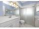 Bright bathroom with white vanity, large mirror, and updated shower at 7777 117Th St, Seminole, FL 33772
