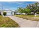 Charming single-story home with a well-manicured lawn, complemented by a long driveway and mature trees at 7777 117Th St, Seminole, FL 33772