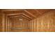 The interior view of the matching shed features wood-paneling, exposed beams, and a useful shelf at 7777 117Th St, Seminole, FL 33772