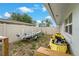 View of the backyard featuring a boat on a trailer and a yellow kayak along the side of the house at 7909 Canna Dr, Port Richey, FL 34668