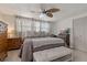 Spacious bedroom featuring a ceiling fan, natural light, and a comfortable bench at the foot of the bed at 7909 Canna Dr, Port Richey, FL 34668