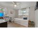 Well-lit bedroom with large windows, a daybed, and a dedicated workspace, ideal for comfort and productivity at 7909 Canna Dr, Port Richey, FL 34668